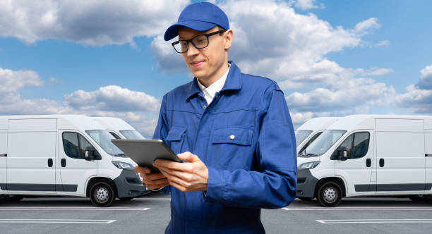 Manager with a digital tablet next to vans. Fleet management.